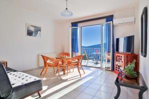 Una sala de estar con mesa y sillas y un balcón. en Myrto Apartments, en Agia Efimia