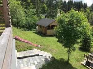 a small cabin with a red slide in a yard at Almhaus Teichalm/Sommeralm in Breitenau