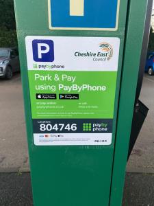a green parking meter with a sign on it at Dove House in Congleton