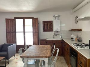 a kitchen with a wooden table and a table and chairs at Apartamentos El Cabo in Mairena