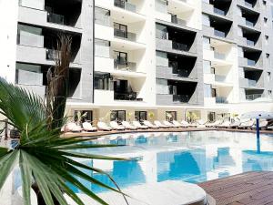 北马马亚-讷沃达里Hotel Building Stefan Resort I Sud的大型公寓楼前的游泳池