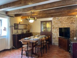 une salle à manger avec une table, des chaises et une télévision dans l'établissement Poet's Rest, à Pieve Santo Stefano