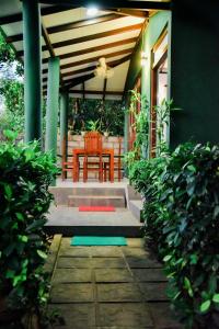 a porch of a house with a table and chairs at Jungle Edge Bungalow Udawalawe in Udawalawe