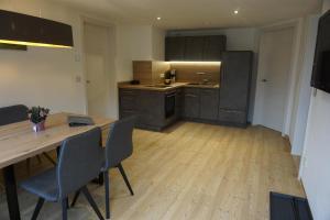 an empty kitchen with a wooden table and chairs at Ferienwohnung Helchenberg in Bad Hindelang +6 photos