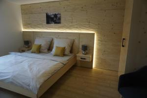 a bedroom with a large bed with a wooden wall at Ferienwohnung Helchenberg in Bad Hindelang