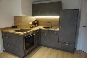 a kitchen with a sink and a refrigerator at Ferienwohnung Helchenberg in Bad Hindelang