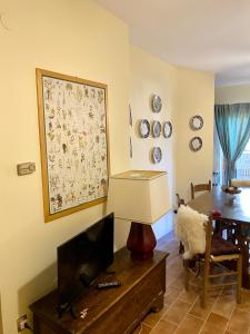 羅卡迪梅佐的住宿－Appartamento con Giardino - Rocca di Mezzo，客厅配有平面电视和桌子。