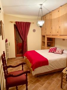 sypialnia z dużym łóżkiem i czerwonym kocem w obiekcie Appartamento con Giardino - Rocca di Mezzo w mieście Rocca di Mezzo