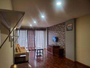 a living room with a staircase and a couch at Star Regency Hotel & Apartments in Brinchang