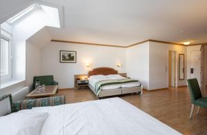 a hotel room with a bed and two chairs at Ambassador Self Check-in Hotel in Lucerne