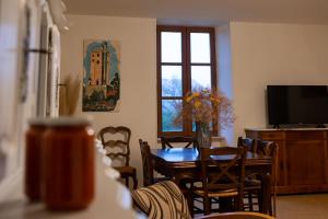 a dining room with a table and chairs and a window at Gîte de Grailhes in Aguessac +11 photos