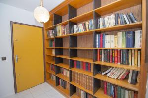 uma biblioteca com prateleiras de madeira cheias de livros em Spacieux T4 Idéal Groupes em Créteil