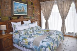 a bedroom with a large bed in a room with windows at MFT GUEST HOUSE in Boksburg