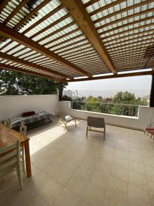 un gran patio al aire libre con pérgola de madera en Villa Sarah in Galilee - All Nations Inn, en Poriyya