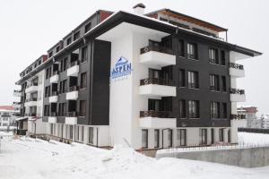 班斯科Dinos 2 Bed Cozy Apart at Bansko close to the lift的前面有雪的大建筑