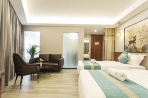 a hotel room with two beds and a couch at Thapae Twins Hotel in Chiang Mai