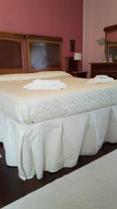 a large bed with a white bedskirts at Corte Posta B&B in Mantova