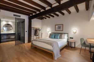 a bedroom with a bed and a table and chairs at EtxeAundi Hotel Boutique in Oñate