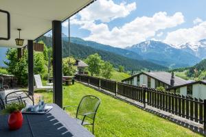 a balcony with a table and chairs and mountains at Jewel Duplex in Fieschertal