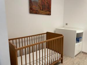 a crib in a room with a painting on the wall at Villa MARIA in Chambon-sur-Lac