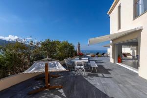 eine Terrasse mit einem Sonnenschirm und Stühlen auf einem Haus in der Unterkunft La Maison sur la Plage in Calcatoggio