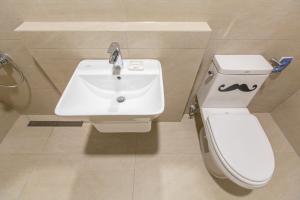 a white toilet sitting next to a sink in a bathroom at Lunamar Pension in Jeju