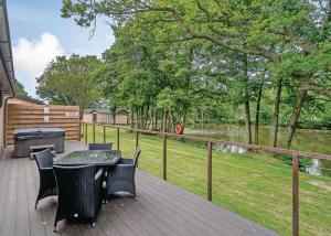 a deck with a table and chairs and a grill at Warrenwood Country Park in Polegate