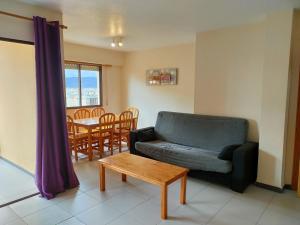 a living room with a couch and a table at Tamaris Playa Solo Familias Serviplaya in Playa de Xeraco