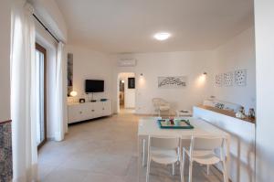 Il comprend une cuisine et un salon avec une table et des chaises. dans l'établissement Villa Pineta, à Valledoria