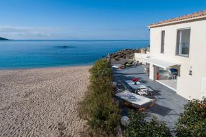une maison sur la plage à côté de l'océan dans l'établissement La Maison sur la Plage, à Calcatoggio