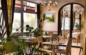 a restaurant with tables and chairs and a chandelier at Le Chagny in Chagny