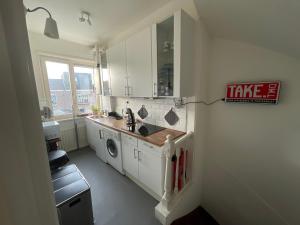 a kitchen with a sink and a washing machine at Comfortable Room in Alkmaar