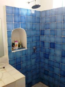 La salle de bains est pourvue de carrelage bleu et d'un mur carrelé bleu. dans l'établissement Villa Vista Mare a Filicudi, à Filicudi
