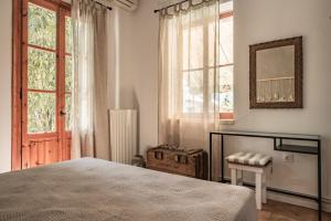 een slaapkamer met een bed en een raam bij Villa Gioia - Secret gem with private garden in Katastárion