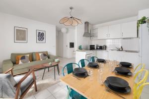 a kitchen and a living room with a table and chairs at NOCNOC - Le Cocon Hypercentre in Toulouse