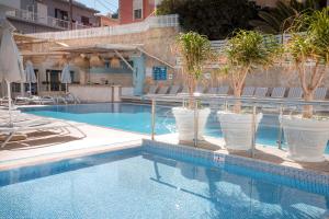 a swimming pool with palm trees in a hotel at Rhodos Horizon Blu-Adults Only in Rhodes Town