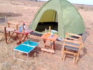 Amanya Double Pitch Tent with Mt Kilimanjaro View في أمبوسيلي: خيمة امامها كراسي وطاولات