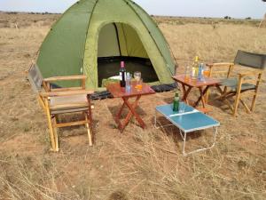 Amanya Double Pitch Tent with Mt Kilimanjaro View في أمبوسيلي: طاولتين وكراسي أمام خيمة