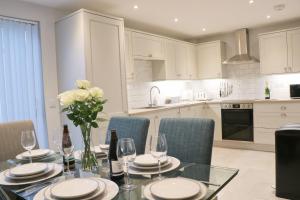 a kitchen with a dining table with wine glasses and flowers at Townhouse, close to harbour with sea views in Padstow