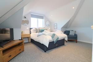 a bedroom with a bed and a blue chair at Townhouse, close to harbour with sea views in Padstow
