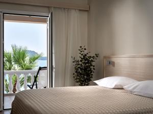 een slaapkamer met een bed en uitzicht op de oceaan bij Gloria Maris Hotel Suites and Villa in Laganas
