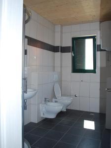 a bathroom with a sink and a toilet and a window at Apartments Dujic in Tribunj