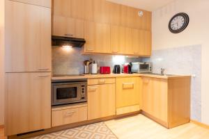 a kitchen with wooden cabinets and a clock on the wall at Cozy Apartment Brussels Centre in Brussels