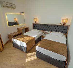 a hotel room with two beds and a mirror at Kleopatra Celine Hotel in Alanya