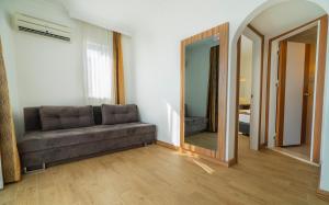 a living room with a couch and a mirror at Kleopatra Celine Hotel in Alanya
