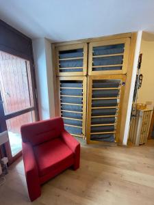 een rode stoel in een kamer met een kast bij Cervinia appartamento monolocale in Breuil-Cervinia