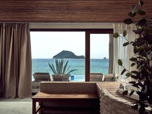 a living room with a couch and a view of the ocean at Gloria Maris Hotel Suites and Villa in Laganas