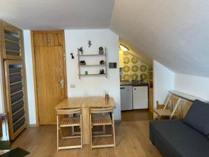 een woonkamer met een tafel en een keuken bij Cervinia appartamento monolocale in Breuil-Cervinia