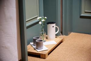 a table with a vase of flowers and two cups at Hotel & Restaurant Linde in Münstertal