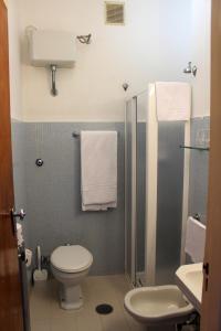 a bathroom with a toilet and a shower with towels at Hotel Mediterranée in Taormina